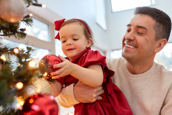 Mutlu baba ve kız bebek Noel ağacını süslüyor. — Stok fotoğraf