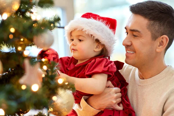 Mutlu baba ve kız bebek Noel ağacını süslüyor. — Stok fotoğraf