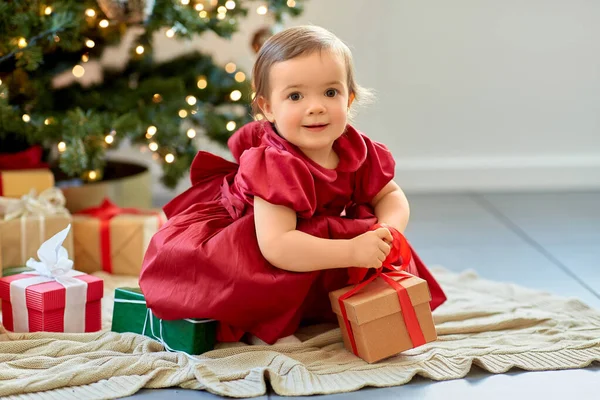 Happy baby girl opening christmas gifts at home — Stock Photo, Image