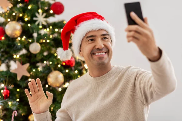 Man with smartphone having video call on christmas — Stock Photo, Image
