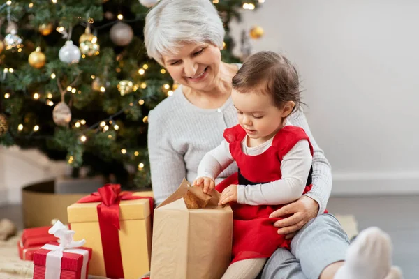 Mormor och liten flicka med julklappar — Stockfoto