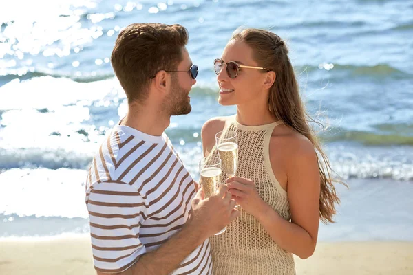 Lyckliga par dricker champagne på sommarstranden — Stockfoto