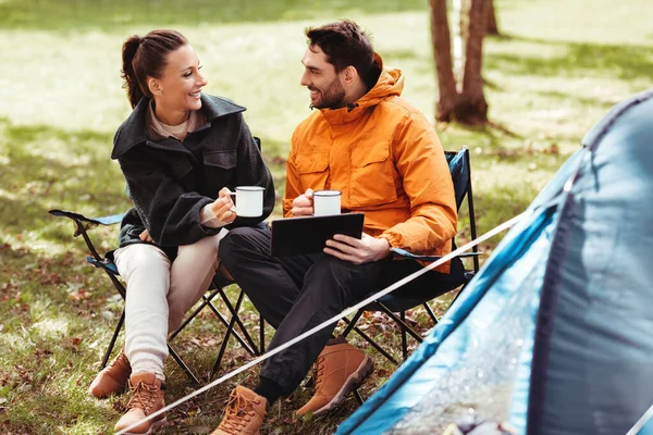 Pareja con tableta pc beber té en el campamento de la tienda — Foto de Stock