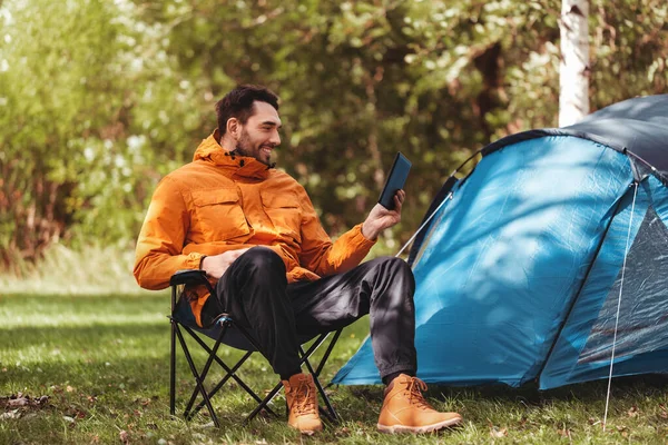 Homem feliz com computador tablet pc no acampamento tenda — Fotografia de Stock