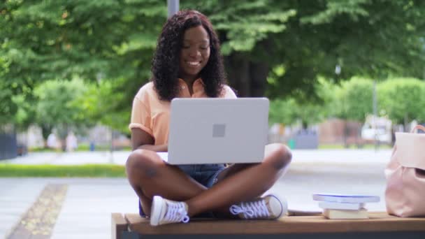 Африканская студентка с ноутбуком и книгами в городе — стоковое видео