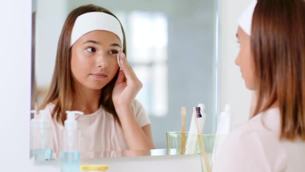 Teenage girl cleaning face skin with cotton disc — Stock Video