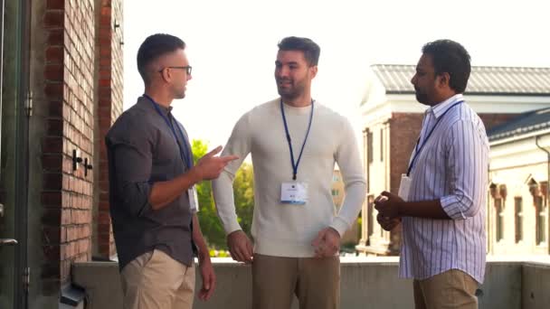 Hombres de negocios con etiquetas con nombres hablando al aire libre — Vídeos de Stock