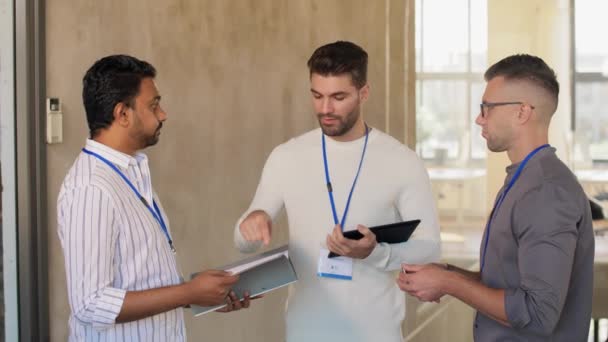 Hombres de negocios con etiquetas de nombres hablando en la oficina — Vídeos de Stock