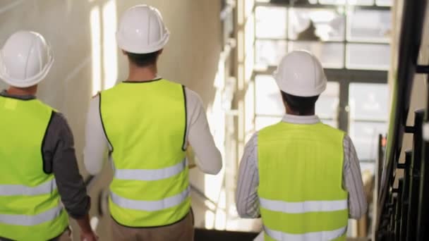 Architects in helmets walking downstairs at office — Stock Video