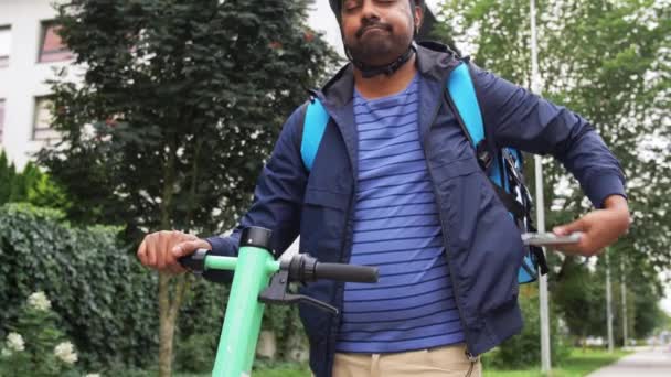 Repartidor con teléfono y bolsa de montar scooter — Vídeo de stock