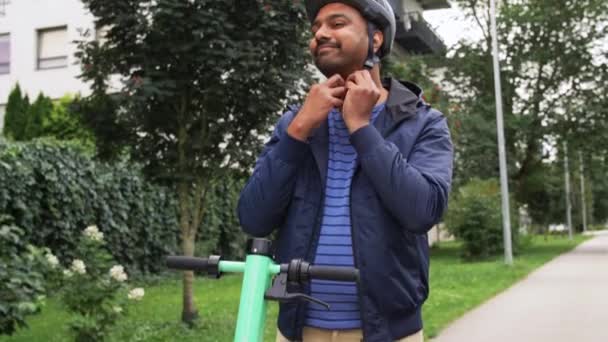 Mann mit Helm fährt Elektroroller auf Straße — Stockvideo