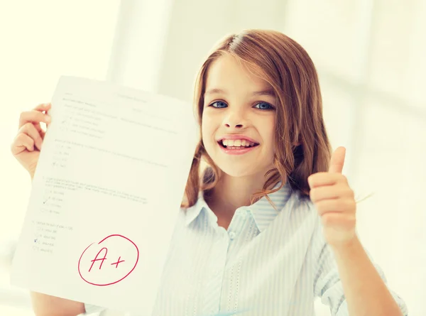 Sonriente niña estudiante con prueba y un grado —  Fotos de Stock