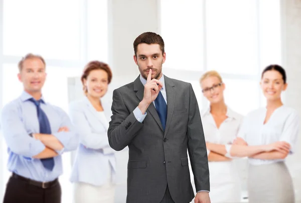 Group of smiling businessmen making hush sign — Stock Photo, Image