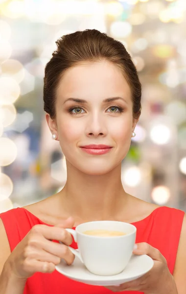 Lächelnde Frau im roten Kleid mit Tasse Kaffee — Stockfoto