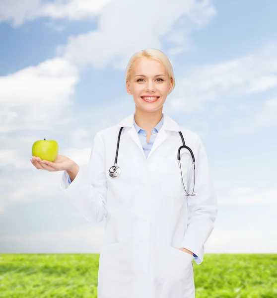 Leende kvinna läkare med grönt äpple — Stockfoto