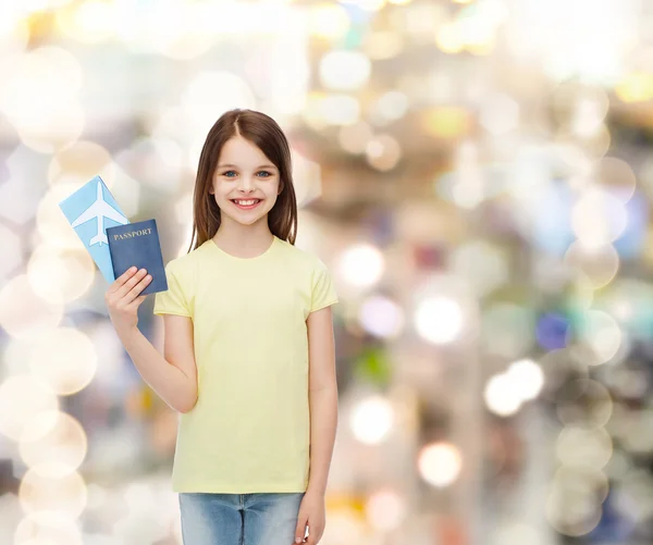 Niña sonriente con billete y pasaporte — Foto de Stock