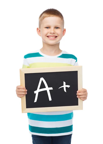 Smiling little boy with blank blackboard — Stock Photo, Image