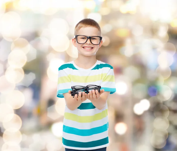 Menino sorridente em óculos segurando óculos — Fotografia de Stock