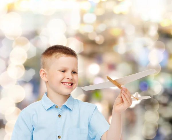 Lachende jongetje houden een houten vliegtuig model — Stockfoto