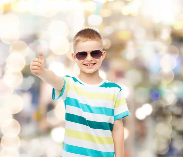 Sonriente niño en gafas de sol mostrando los pulgares hacia arriba — Foto de Stock