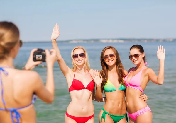 Grupo de mulheres sorridentes fotografando na praia — Fotografia de Stock