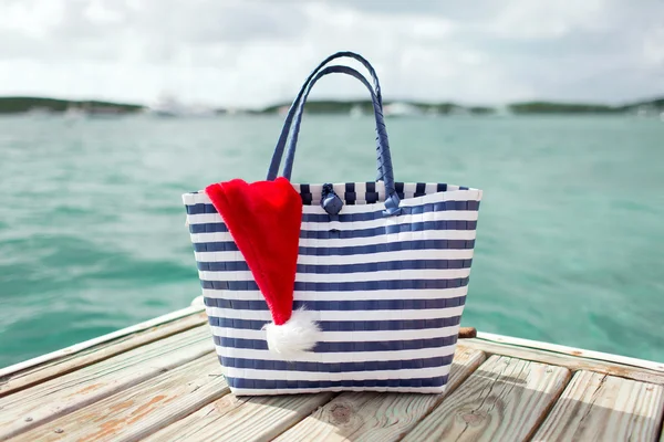 Närbild på stranden påse och santa helper hatt — Stockfoto