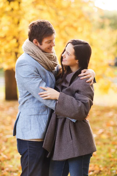 Couple souriant étreignant dans le parc d'automne — Photo