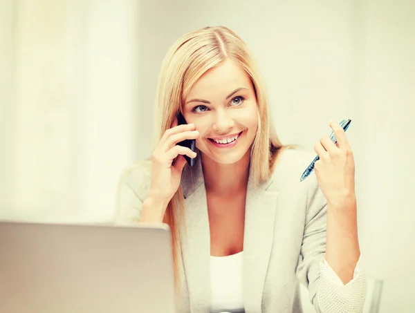 Zakenvrouw met laptop en mobiele telefoon — Stockfoto