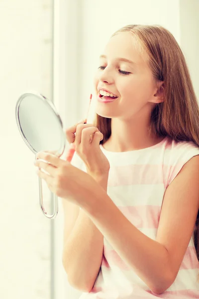Chica adolescente con brillo de labios y espejo — Foto de Stock