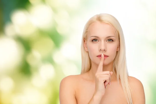 Спокойная молодая женщина с пальцем на губах — стоковое фото