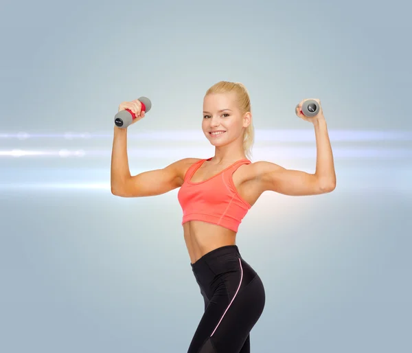 Smiling beautiful sporty woman with dumbbells — Stock Photo, Image