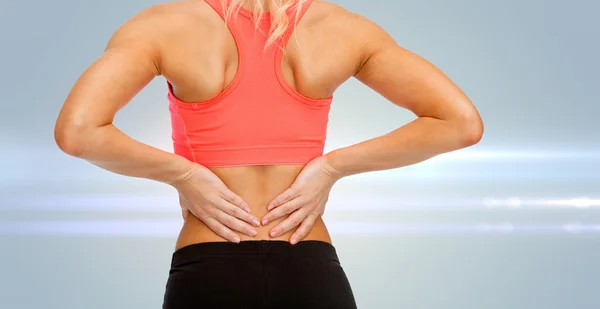 Close up of sporty woman touching her back — Stock Photo, Image