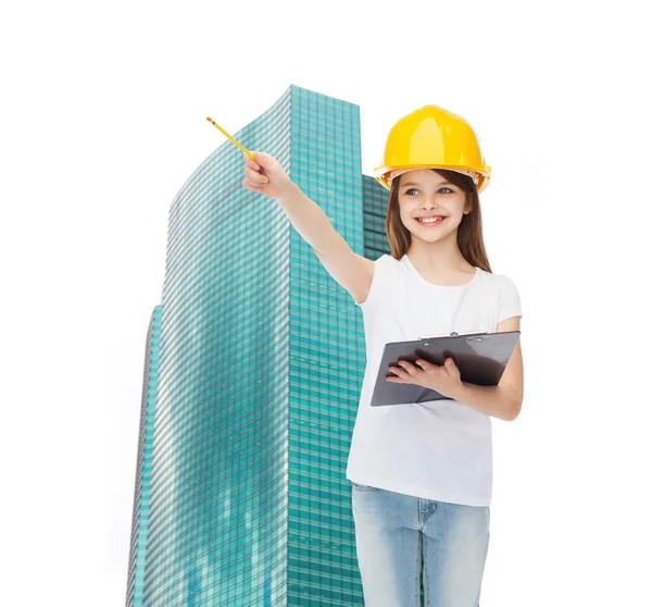 Niña sonriente en hardhat con portapapeles — Foto de Stock