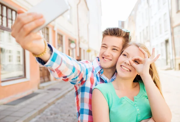 Lachende paar met smartphone in stad — Stockfoto