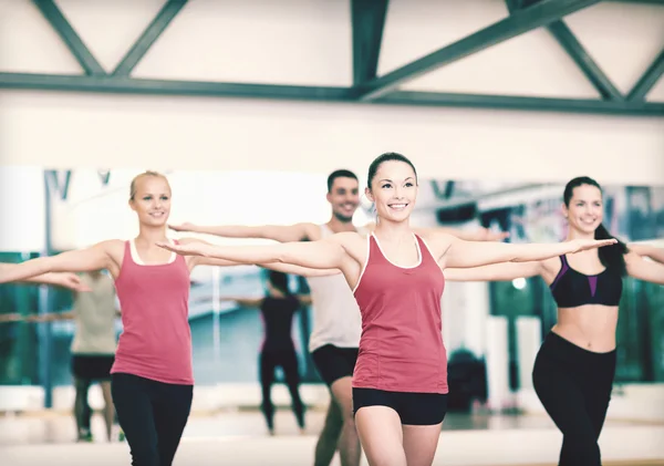 Grupp av leende människor tränar i gymmet — Stockfoto