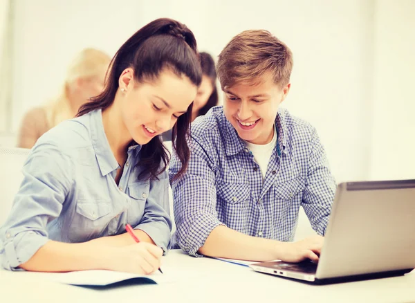 Students with laptop and notebooks at school — Stock Photo, Image