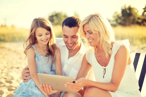 Familia sonriente en la playa con tablet PC —  Fotos de Stock