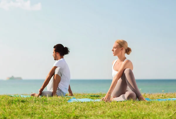 Çift gülümseyen açık havada yapım yoga egzersizleri — Stok fotoğraf