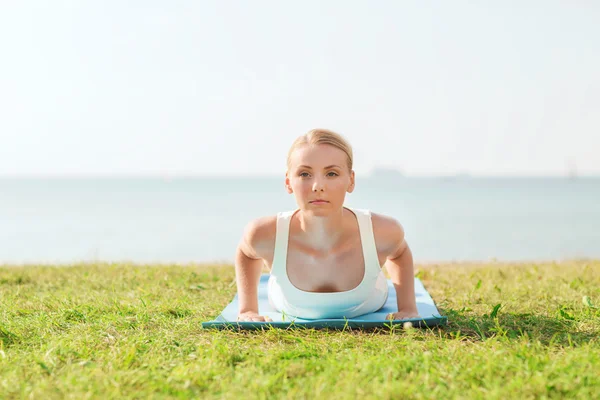Jovem mulher fazendo exercícios de ioga ao ar livre — Fotografia de Stock