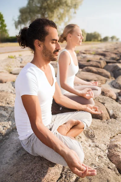 Glimlachend paar oefeningen maken yoga buiten — Stockfoto