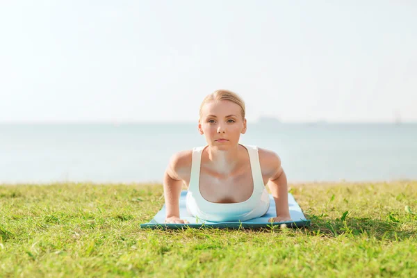 Mujer joven haciendo ejercicios de yoga al aire libre Fotos de stock