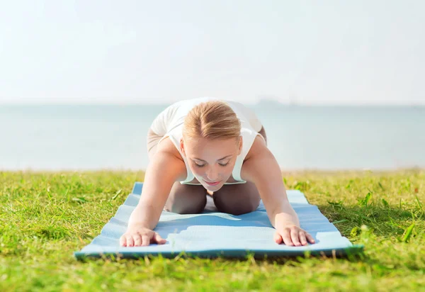 Ung kvinna att göra yogaövningar utomhus — Stockfoto