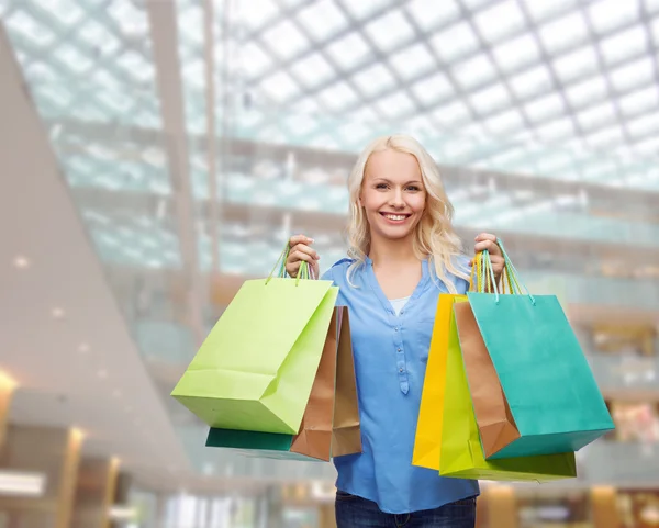 Femme souriante avec de nombreux sacs à provisions — Photo