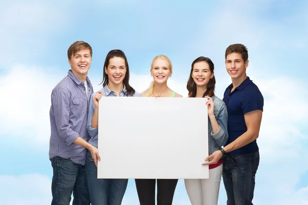 Grupo de estudiantes de pie con pizarra blanca en blanco — Foto de Stock