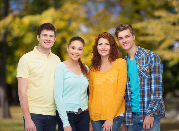 Group of smiling teenagers over green park — Stock Photo, Image