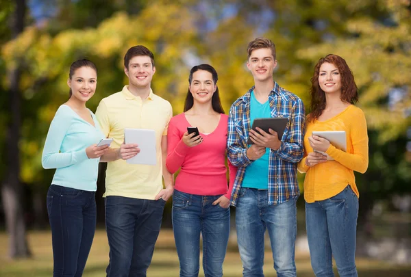 Grupp av tonåringar med smartphones och tablet pc — Stockfoto