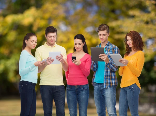 Group of teenagers with smartphones and tablet pc Stock Image