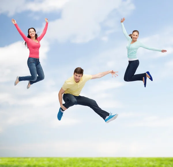 Skupina usměvavá teenagerů skákání ve vzduchu — Stock fotografie