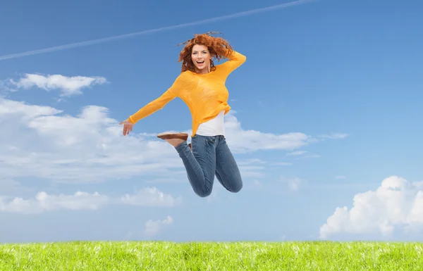 Smiling young woman jumping in air — Stock Photo, Image