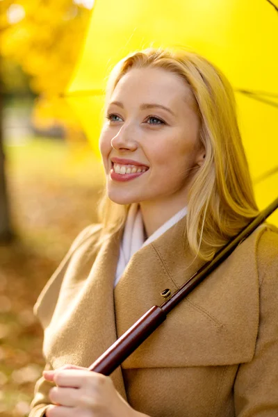 Donna sorridente con ombrello nel parco autunnale — Foto Stock